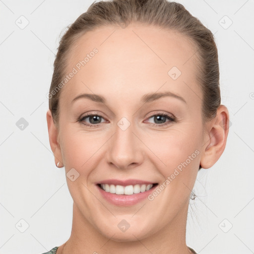 Joyful white young-adult female with medium  brown hair and grey eyes