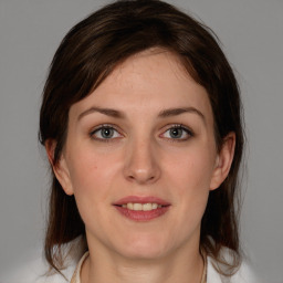 Joyful white young-adult female with medium  brown hair and grey eyes