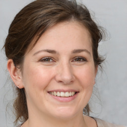 Joyful white young-adult female with medium  brown hair and grey eyes