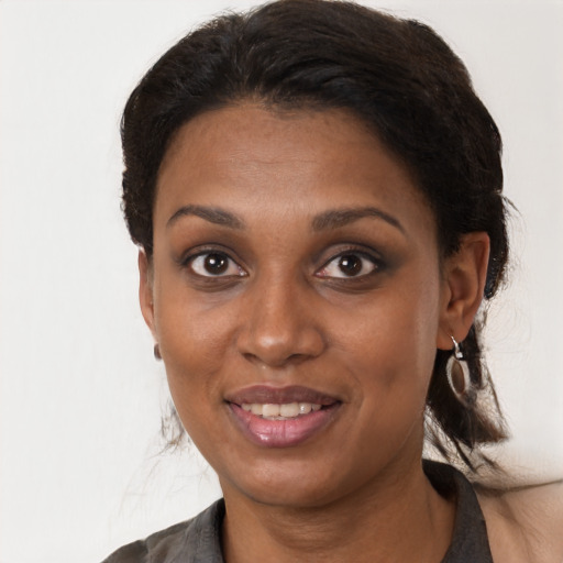 Joyful black young-adult female with medium  brown hair and brown eyes
