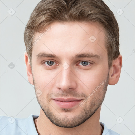 Joyful white young-adult male with short  brown hair and grey eyes