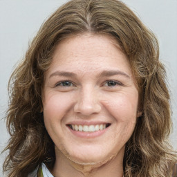 Joyful white young-adult female with long  brown hair and green eyes