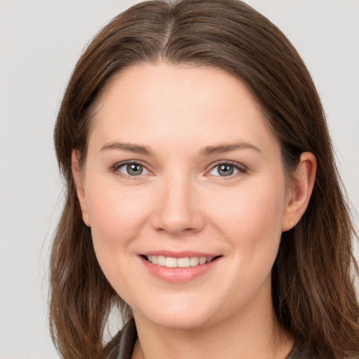 Joyful white young-adult female with long  brown hair and brown eyes