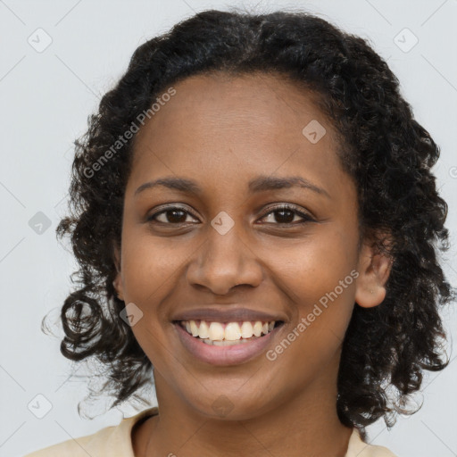 Joyful black young-adult female with long  brown hair and brown eyes