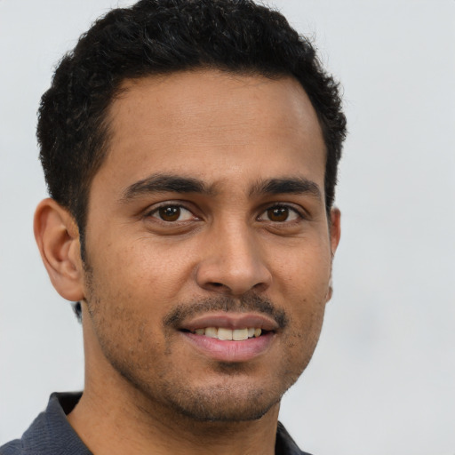 Joyful latino young-adult male with short  brown hair and brown eyes