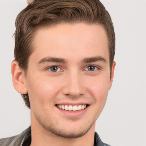 Joyful white young-adult male with short  brown hair and grey eyes