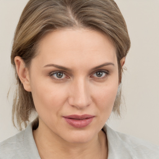 Joyful white young-adult female with medium  brown hair and grey eyes