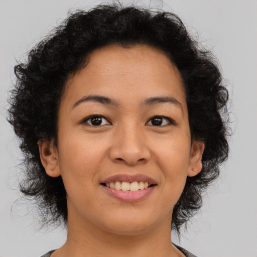 Joyful black young-adult female with medium  brown hair and brown eyes