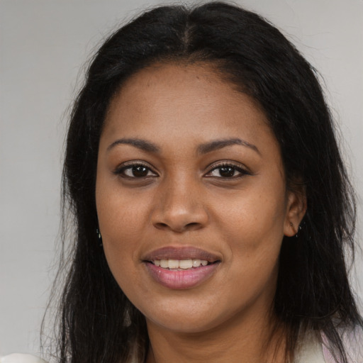 Joyful black young-adult female with long  black hair and brown eyes