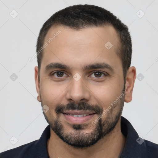 Joyful white young-adult male with short  black hair and brown eyes