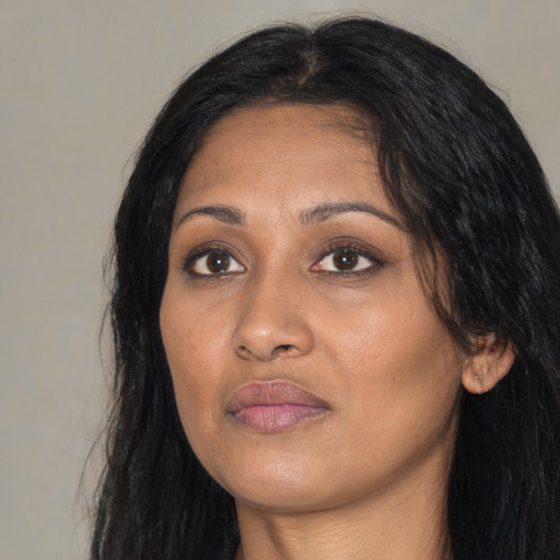 Joyful black adult female with long  black hair and brown eyes