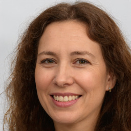 Joyful white adult female with long  brown hair and brown eyes