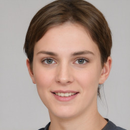 Joyful white young-adult female with medium  brown hair and grey eyes