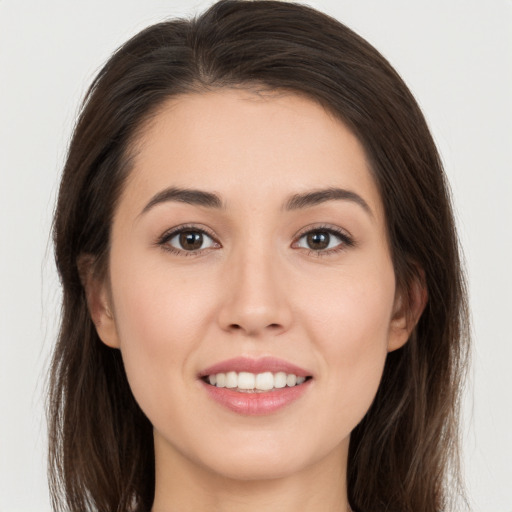 Joyful white young-adult female with long  brown hair and brown eyes