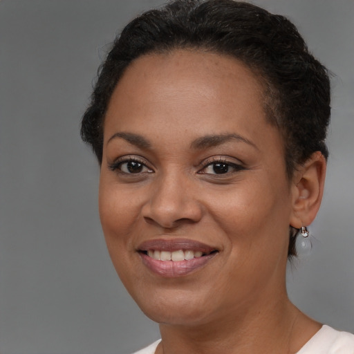 Joyful black young-adult female with short  brown hair and brown eyes