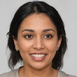 Joyful latino young-adult female with medium  brown hair and brown eyes