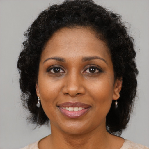Joyful black young-adult female with medium  brown hair and brown eyes