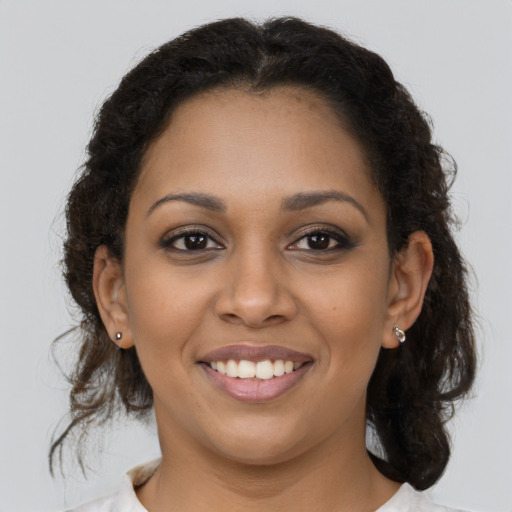 Joyful black young-adult female with medium  brown hair and brown eyes
