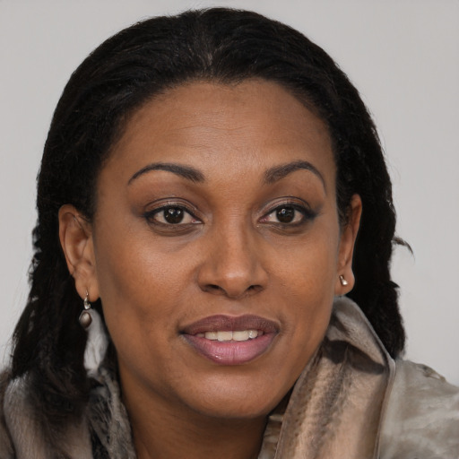 Joyful black adult female with long  brown hair and brown eyes