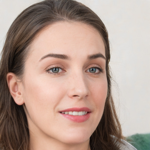 Joyful white young-adult female with long  brown hair and grey eyes