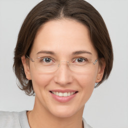 Joyful white adult female with medium  brown hair and grey eyes