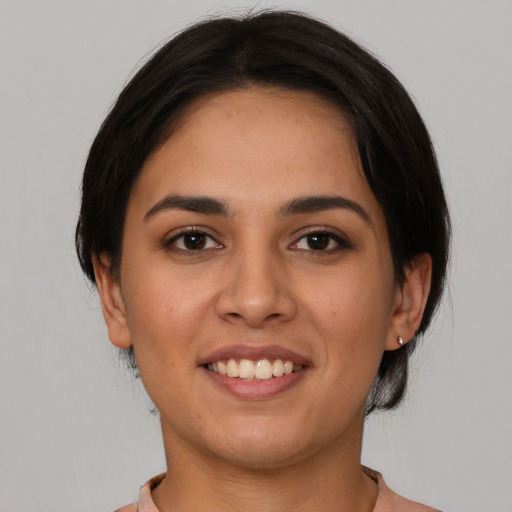 Joyful latino young-adult female with medium  brown hair and brown eyes