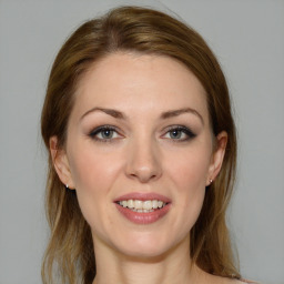 Joyful white young-adult female with medium  brown hair and grey eyes