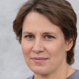 Joyful white adult female with medium  brown hair and grey eyes