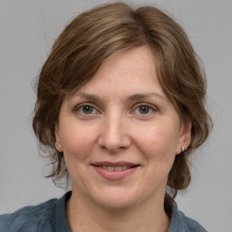 Joyful white adult female with medium  brown hair and grey eyes