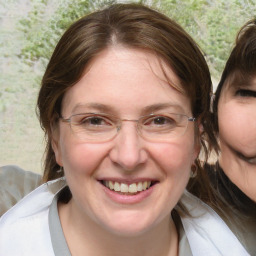 Joyful white adult female with medium  brown hair and blue eyes