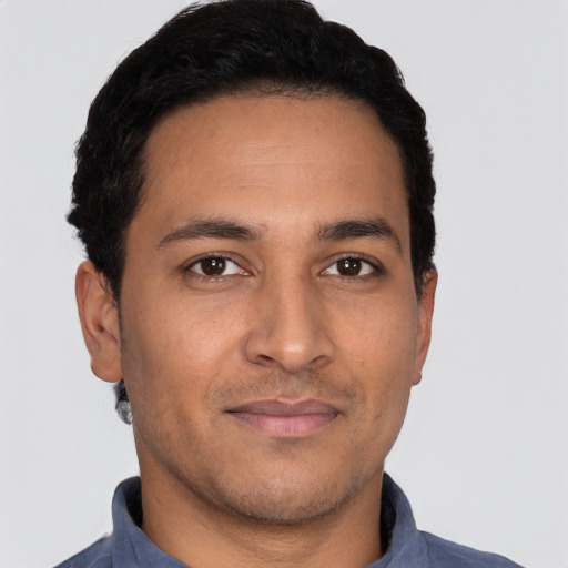 Joyful latino young-adult male with short  black hair and brown eyes