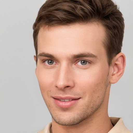 Joyful white young-adult male with short  brown hair and grey eyes