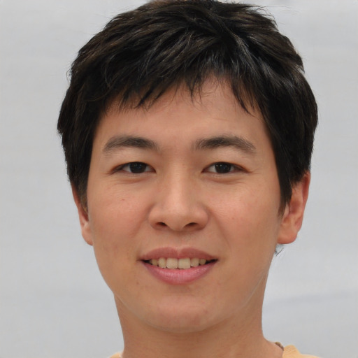 Joyful asian young-adult male with short  brown hair and brown eyes
