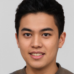 Joyful asian young-adult male with short  brown hair and brown eyes