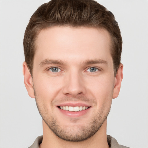 Joyful white young-adult male with short  brown hair and grey eyes