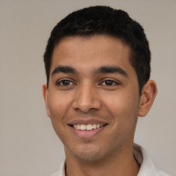 Joyful latino young-adult male with short  black hair and brown eyes