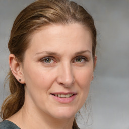 Joyful white adult female with medium  brown hair and blue eyes