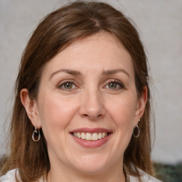 Joyful white adult female with medium  brown hair and grey eyes