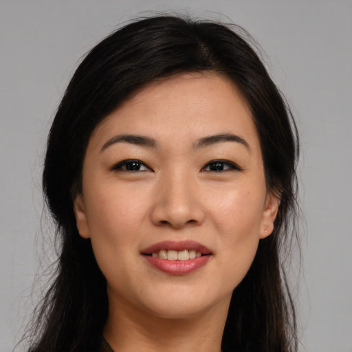 Joyful asian young-adult female with long  brown hair and brown eyes
