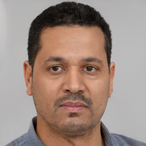 Neutral latino adult male with short  black hair and brown eyes