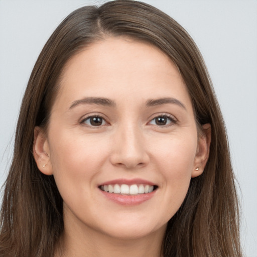 Joyful white young-adult female with long  brown hair and brown eyes