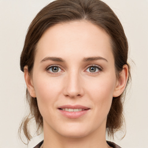 Joyful white young-adult female with medium  brown hair and grey eyes