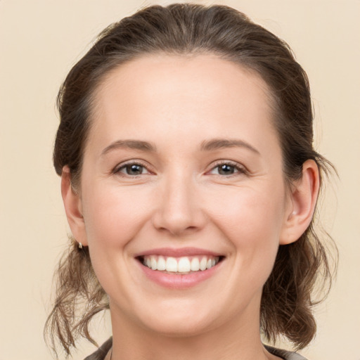 Joyful white young-adult female with medium  brown hair and grey eyes