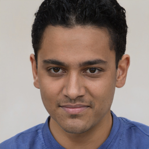 Joyful latino young-adult male with short  brown hair and brown eyes