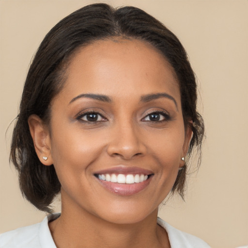 Joyful latino young-adult female with medium  brown hair and brown eyes