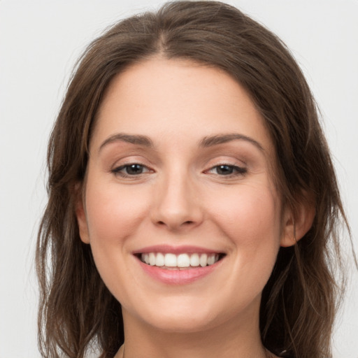 Joyful white young-adult female with long  brown hair and grey eyes