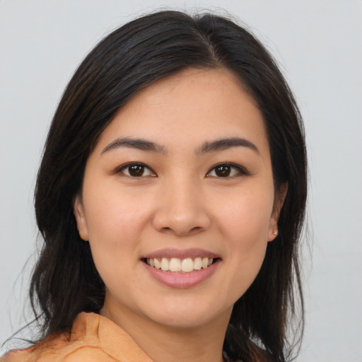 Joyful latino young-adult female with long  brown hair and brown eyes