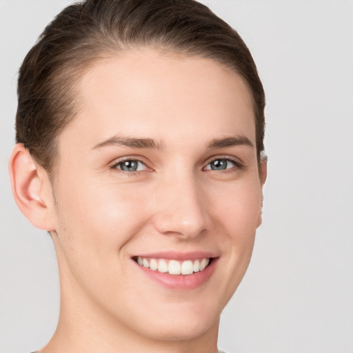 Joyful white young-adult female with short  brown hair and grey eyes