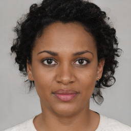 Joyful black young-adult female with short  brown hair and brown eyes