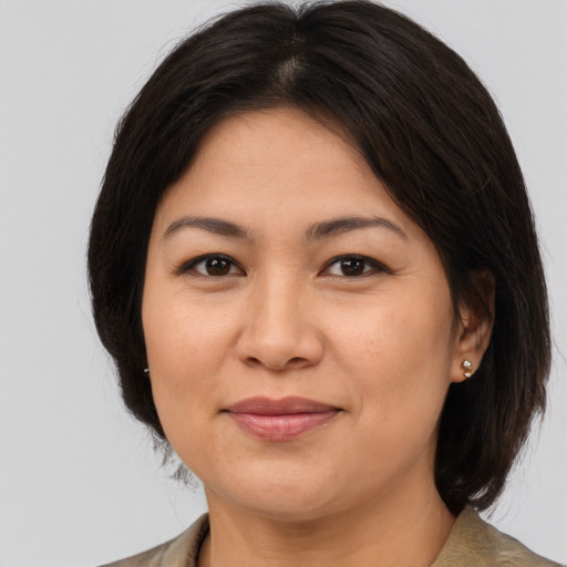 Joyful asian adult female with medium  brown hair and brown eyes